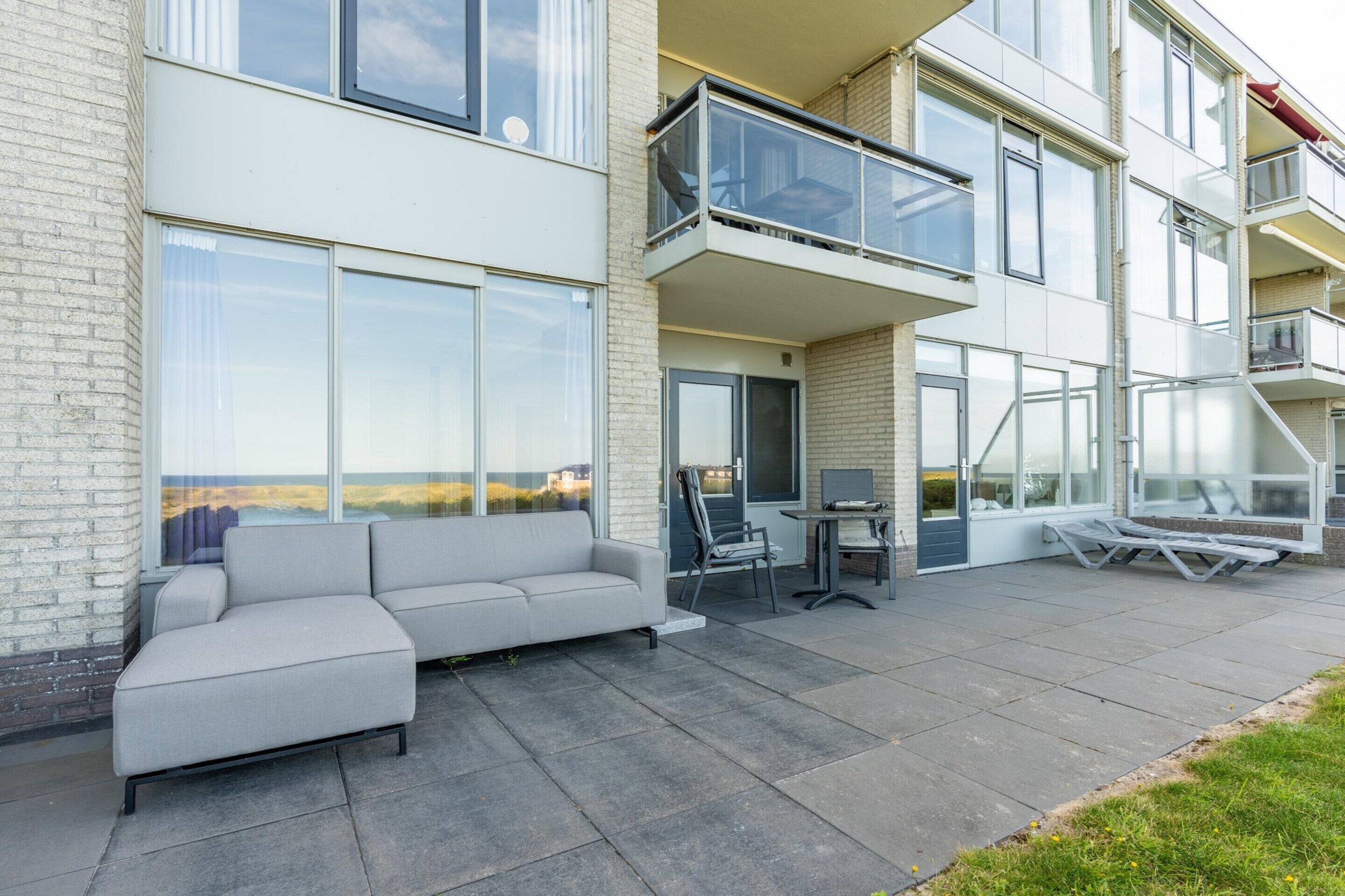 Un apartamento moderno con balcón, sofá y comedor.