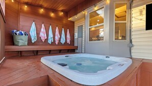A hot tub on a wooden deck with a bench and towels. - Spacious Family Retreat: Central/Hot Tub/Pool Table/Fire Pit/Kids Toys/3KingBeds (Arvada)