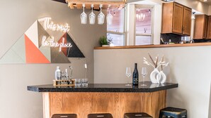 A modern kitchen with a bar area, wooden cabinets, and bar stools. - Spacious Family Retreat: Central/Hot Tub/Pool Table/Fire Pit/Kids Toys/3KingBeds (Arvada)