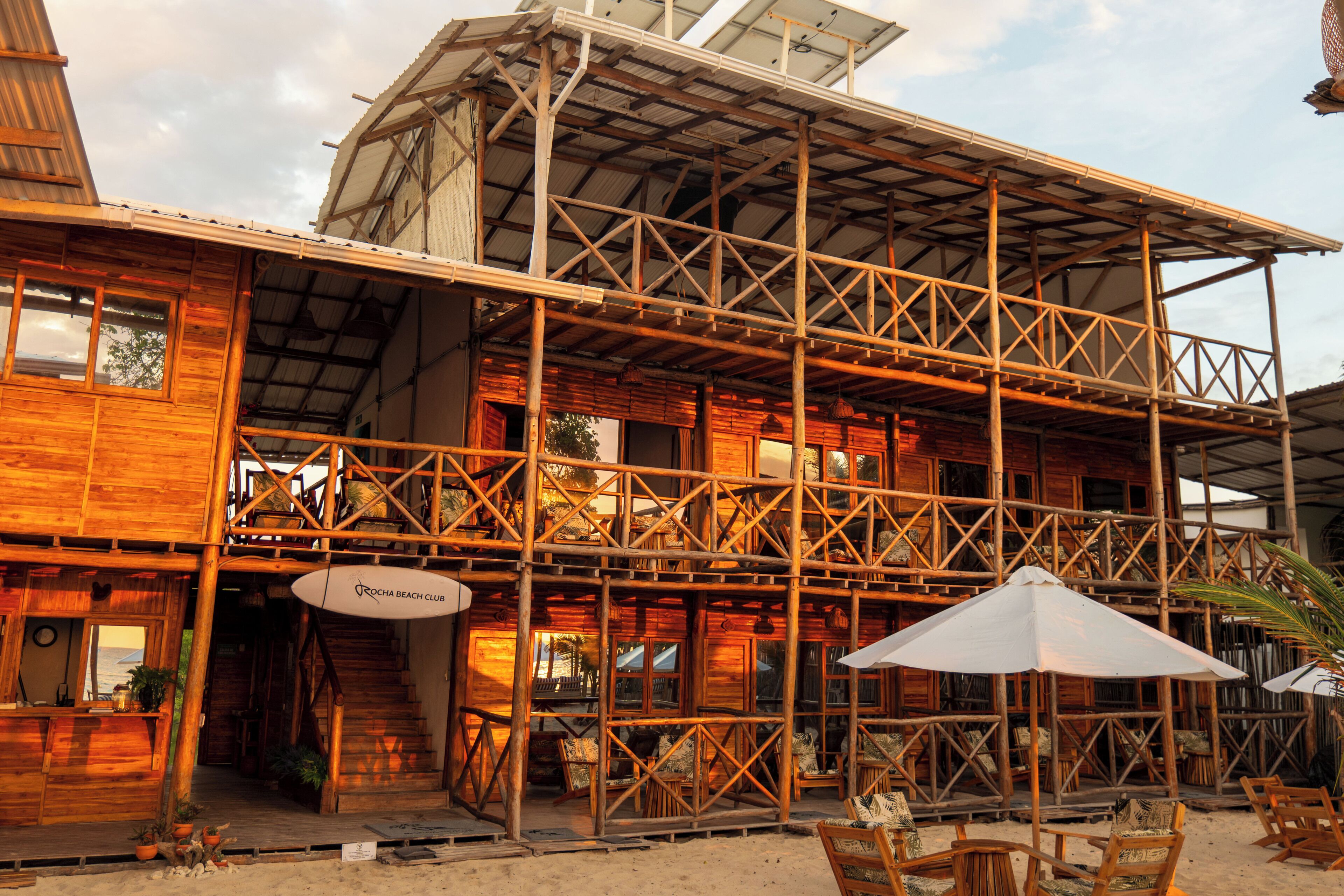 A wooden building with a balcony and outdoor seating area.