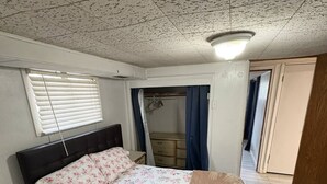 A bedroom with a bed, a bedside table, a wardrobe, and a window with blinds. - Serene 2-bedroom apartment in Provo (Provo)
