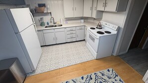 A compact kitchen with white cabinets, a built-in oven, and a sink. - Serene 2-bedroom apartment in Provo (Provo)