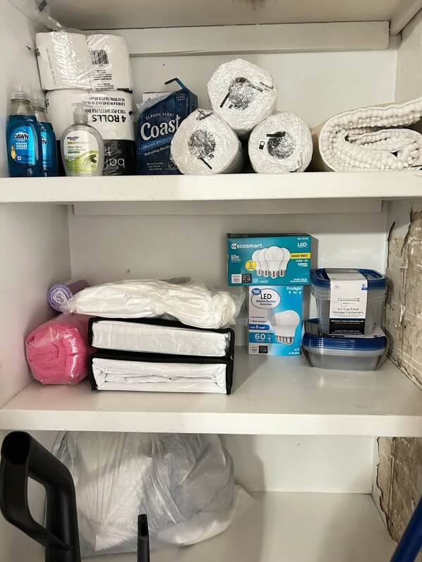 A storage shelf with various items including cleaning supplies, personal care products, and food storage containers.