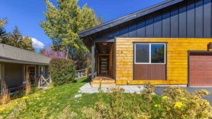 A modern house with a wooden exterior and a garage. - The Timberline House | Modern Mountain Comfort | Walk to Town & Near Lifts (Ketchum)