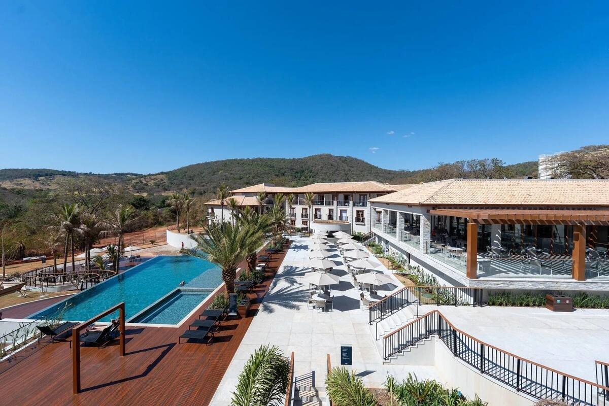 Ein Resort mit Pool, Sitzgelegenheiten im Freien und Blick auf die Hügel.