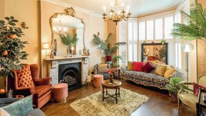 Una sala de estar acogedora con chimenea, asientos mullidos y un espejo grande.