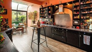 Cocina moderna con una isla central, armarios negros y un amplio ventanal con vistas a un jardín.