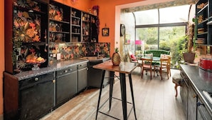 Una cocina con armarios oscuros, una mesa de madera y ventana con vistas a un jardín.