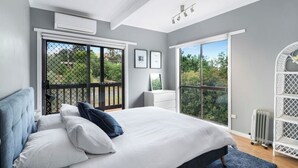 A bedroom with a large bed, a dresser, and a window with a view of greenery. - Lakeview Retreat Bonnie Doon - Sleeps 11 (Bonnie Doon)