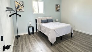 A bedroom with a bed, a ceiling fan, a window, and artwork on the walls. - Modern 2-bedroom apartment in Nassau, steps away from the beach. (Nassau)