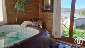 A hot tub in a wooden room with a view of a rural landscape. - Le Grenier d'Alfred - MOUZIEYS PANENS (MOUZIEYS PANENS)