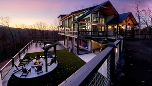 A modern two-story house with a deck, outdoor seating, and a fire pit. - Beartopia - Indoor Splashes, Scenic Hot Tub Soaks, Fireside Sips & Games Galore (Sevierville)