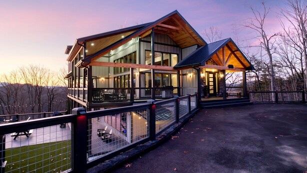 A modern building with large windows and a covered outdoor area. - Beartopia - Indoor Splashes, Scenic Hot Tub Soaks, Fireside Sips & Games Galore (Sevierville)