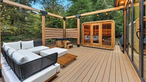 Une terrasse en bois avec un canapé et un jacuzzi.