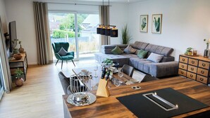A modern living room with a sofa, dining table, and a view of the outdoors. - am Sonnenhang by Interhome (Attendorn)