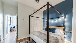A modern bedroom with a four-poster bed, a large window, and a view of the outdoors. - Modern  Bright 1-bedroom condo in Rittenhouse Square- Center City Philadelphia (Philadelphia)