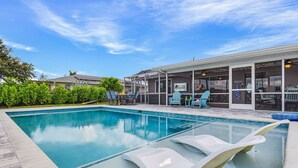 Une piscine avec des chaises longues, un patio couvert et un panneau indiquant l’emplacement du restaurant.