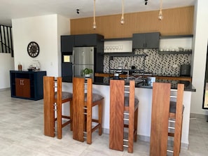A modern kitchen with a central island, bar stools, and a built-in oven. - Villa Tula.  An oasis of tranquility for the whole family in Sosua. (Sosúa)