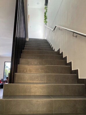 A staircase with a metal handrail and a plant on the wall. - Villa Tula.  An oasis of tranquility for the whole family in Sosua. (Sosúa)