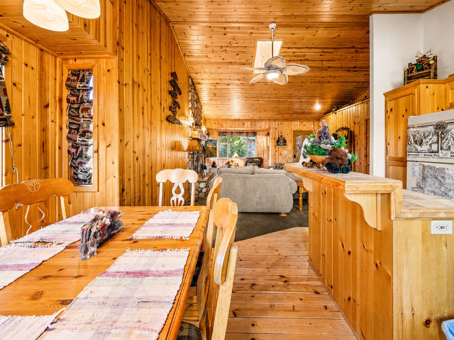 Un interior de madera con comedor, sofá y encimera de cocina.