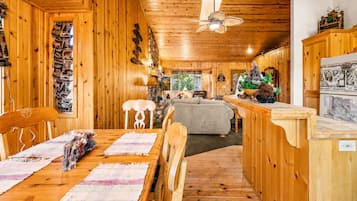 Un interior de madera con comedor, sofá y encimera de cocina.