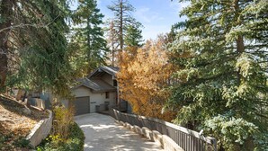 A pathway leading to a building surrounded by trees. - Modern Primrose - Spacious 3 BR Mountain Cabin | Decks, A/C, Game Room & Near Ski, Zoo & Golf (Big Bear Lake)