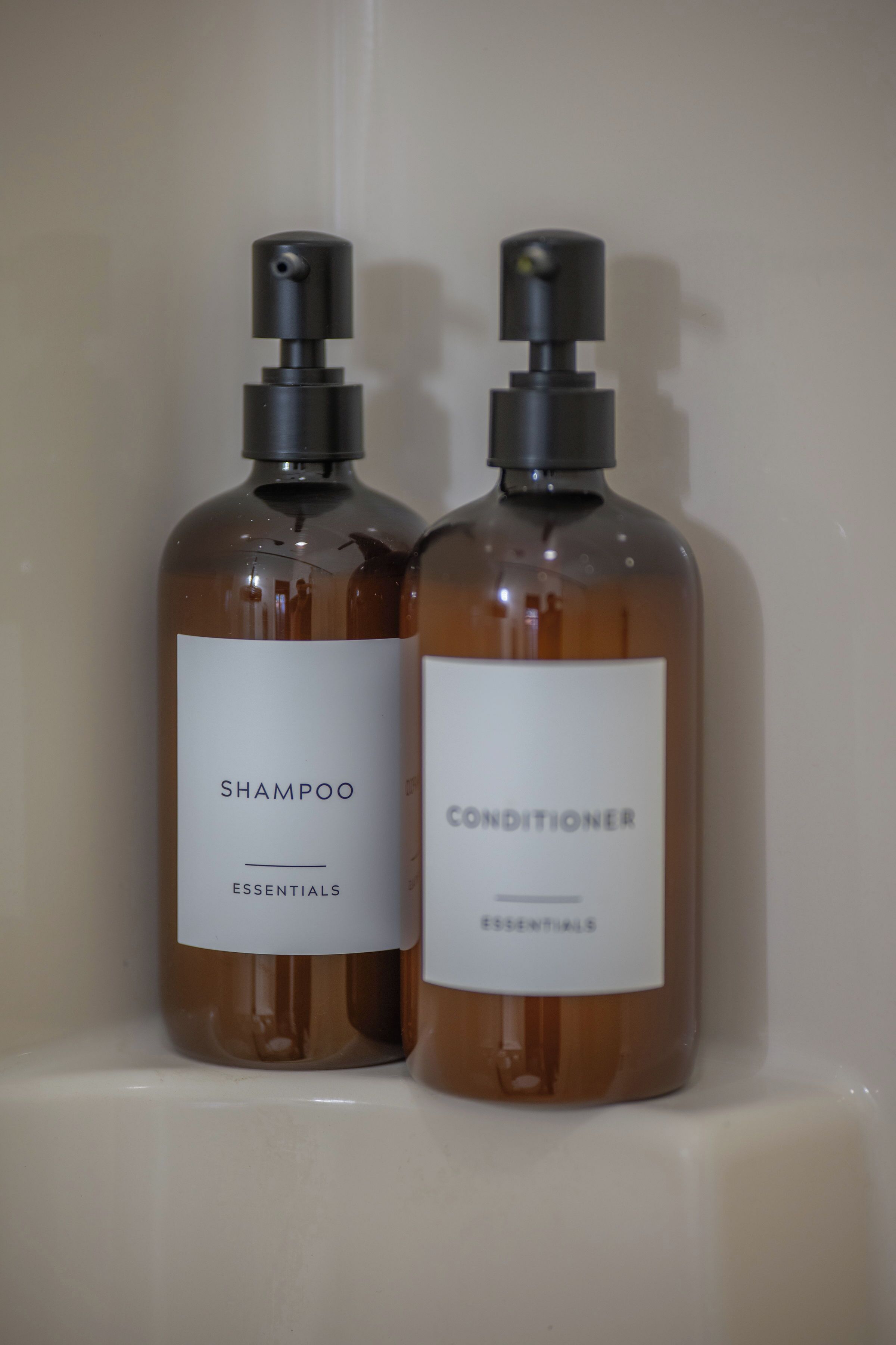 Zwei Flaschen Shampoo und Conditioner auf einem Regal.