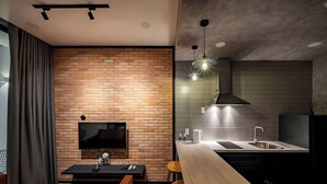 Una cucina moderna con parete in mattoni, tavolo da pranzo in legno e TV a incasso.