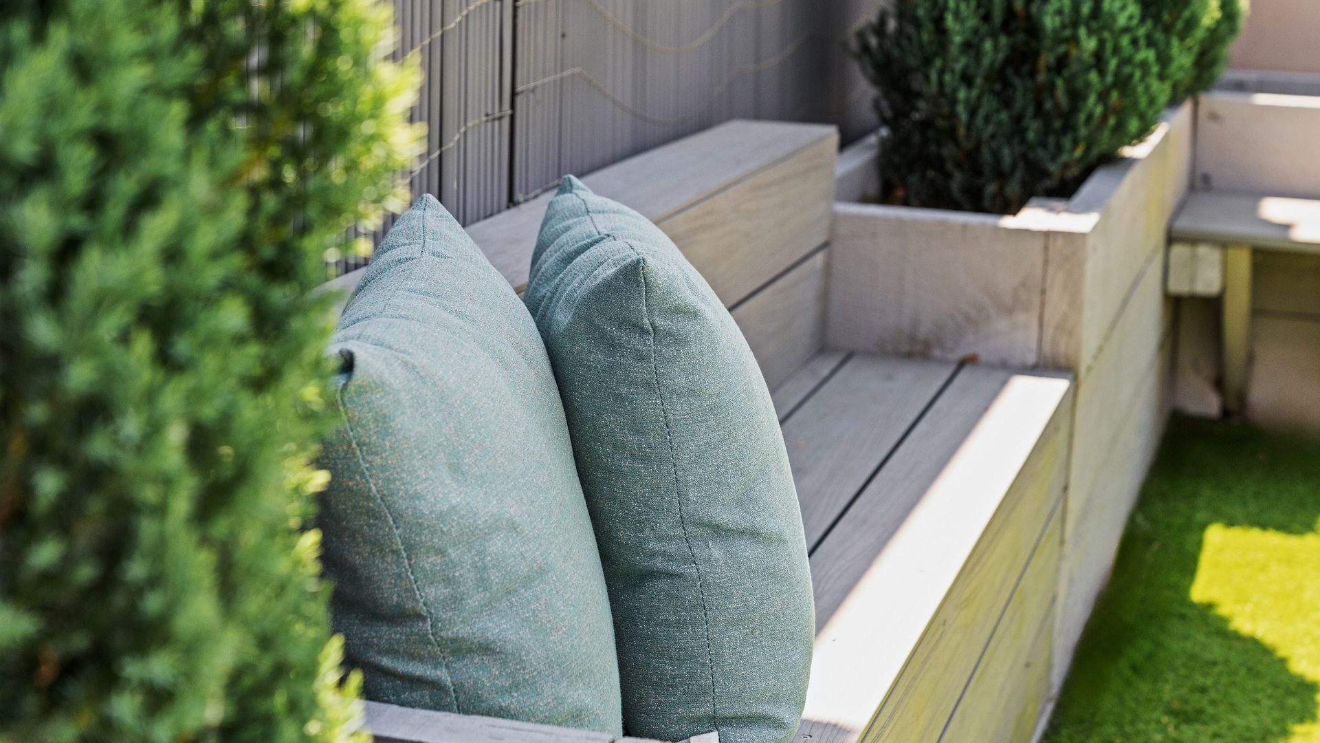 A wooden bench with two cushions.