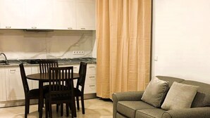 A compact living space with a dining area, a sofa, and a bed. - Joli Beach House - Charming Second Floor T1 Center - With Balcony (Sal)