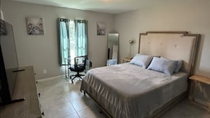 A bedroom with a bed, a desk, and a chair. - 3-bedroom house in welcoming Port Charlotte with AC (Port Charlotte)