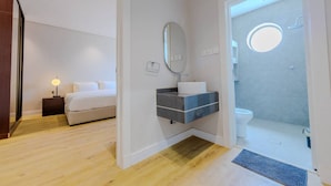 A modern bathroom with a toilet, sink, and mirror. - Han Dhahrat Laban (Riyadh)