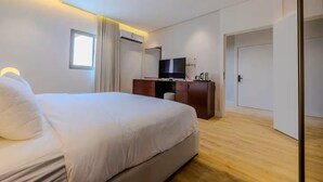 A modern hotel room with a large bed, a desk with a flat-screen TV, and a wardrobe. - Han Dhahrat Laban (Riyadh)