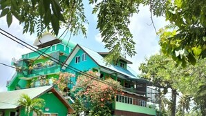 A two-story building with a green facade and a balcony. - Zackry Guesthouse (Langkawi)