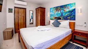 Ein Schlafzimmer mit einem Bett, einem Gemälde, einem Holzschrank, einem Nachttisch und einer Bank.