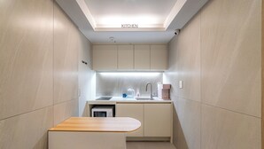 A compact kitchen with a built-in microwave, a sink, and a coffee maker. - Hi Dongdaemun Hostel (Seoul)
