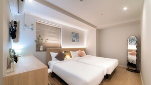A modern hotel room with two beds, a desk, a mirror, and a window with blinds. - Hi Dongdaemun Hostel (Seoul)