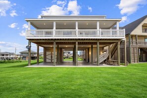 A two-story house with a covered patio and a staircase leading to the upper level.