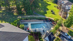 A residential area with a swimming pool, patio furniture, and a view of neighboring houses. - Lake Martin Condo-charming near Auburn-Dadeville in Stillwater (Dadeville)