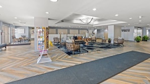 A spacious lobby with a central seating area, a reception desk, and a display of brochures.