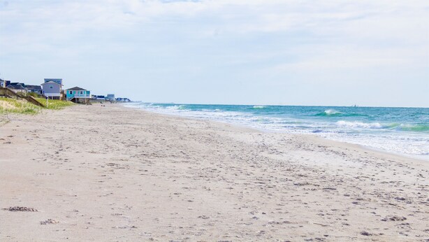 Une plage bordée d’une rangée de maisons.