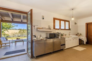A modern kitchen with stainless steel appliances, a large window, and a view of the outdoors. - Beautiful villa with pool in the hills of Le Marche,20 minutes from the beaches of Porto San Giorgio (Ponzano di Fermo)