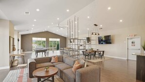 A spacious living area with a sofa set, a dining table, and a TV mounted on the wall. - Contemporary Hideout - 7min to Clemson University (Central)