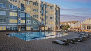 A swimming pool with lounge chairs and a multi-story building with balconies. - Contemporary Hideout - 7min to Clemson University (Central)