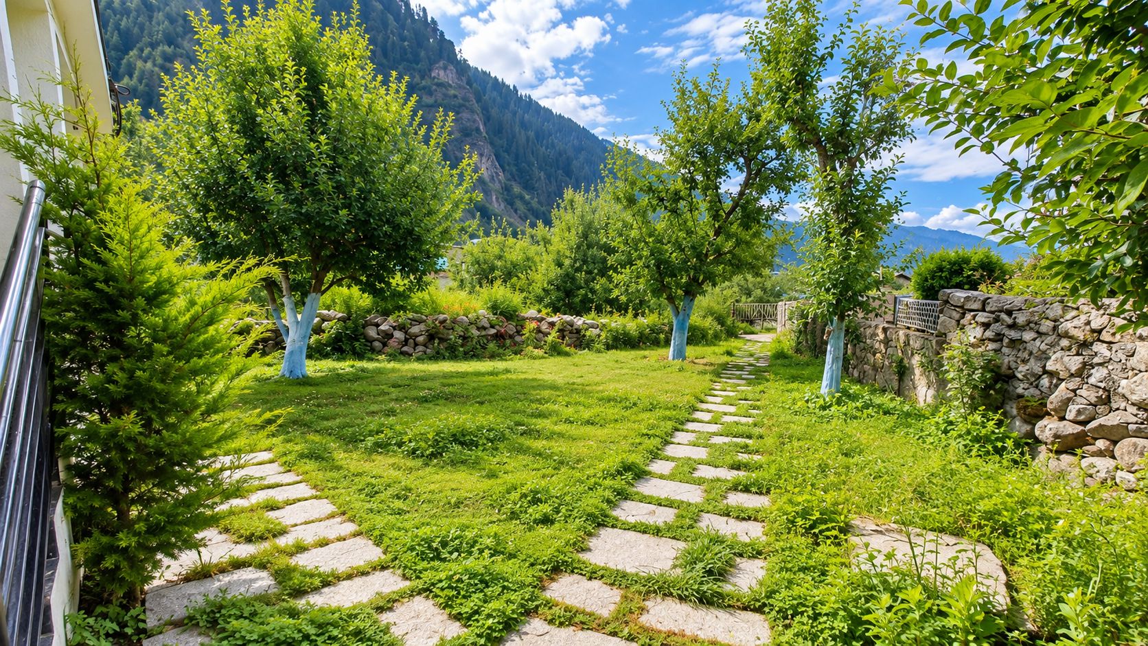A stone pathway leading through a lush garden with trees and a mountain backdrop.