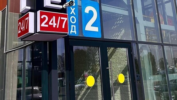 Un bâtiment sur lequel est apposée une enseigne indiquant « HÔTEL DE LUXE » et le numéro « 2 », qui précise l’adresse. L’enseigne comporte également une mention indiquant que l’hôtel est ouvert 24 heures sur 24, 7 jours sur 7.