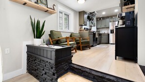 Eine moderne Küche mit Einbauherd, Holzschränken und einem schwarzen Kühlschrank.