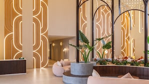 A modern lobby with a reception desk, seating areas, and decorative lighting. - Mangalam Resort and Spa - Member of Absolute Collection   (Gangapur)