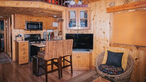 Ein Holzblockhaus-Innenraum mit Küche, Essbereich und einer gemütlichen Sitzecke.