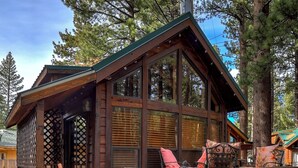 Eine Holzhütte mit Veranda, einem Willkommensschild und einer Bank.